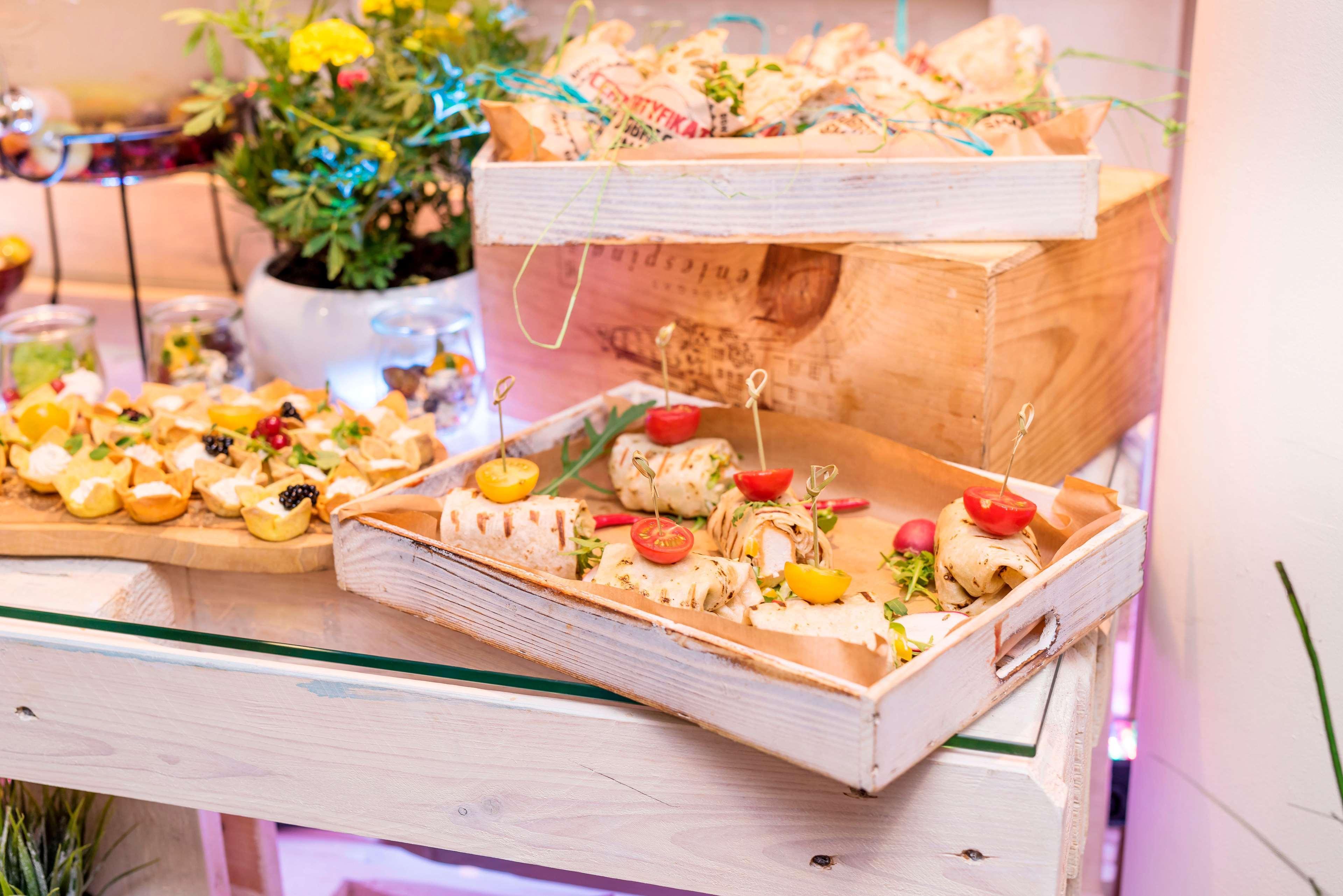 Radisson Blu Hotel Cracovia Esterno foto The photo displays an elegant food presentation featuring two trays of bite-sized appetizers. 

In the foreground, a wooden tray holds assorted canapés topped with various garnishes, including pieces of vegetables and herbs. There are small skewers h